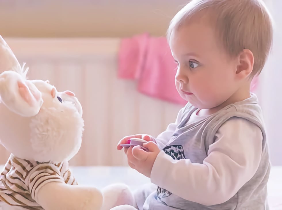 Baby interacting with bunny rabbit toy
